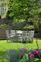 white wooden dining table with chairs set on grass