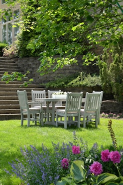 white wooden dining table with chairs set on grass