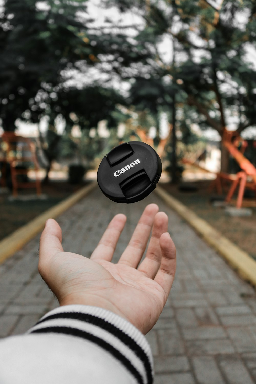 selective focus photo of person's hand throw the cover of DSLR camera
