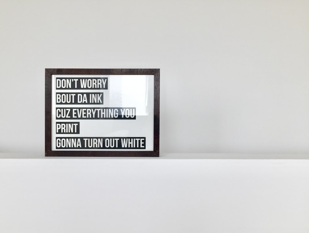 brown wooden framed quote decor on white surface