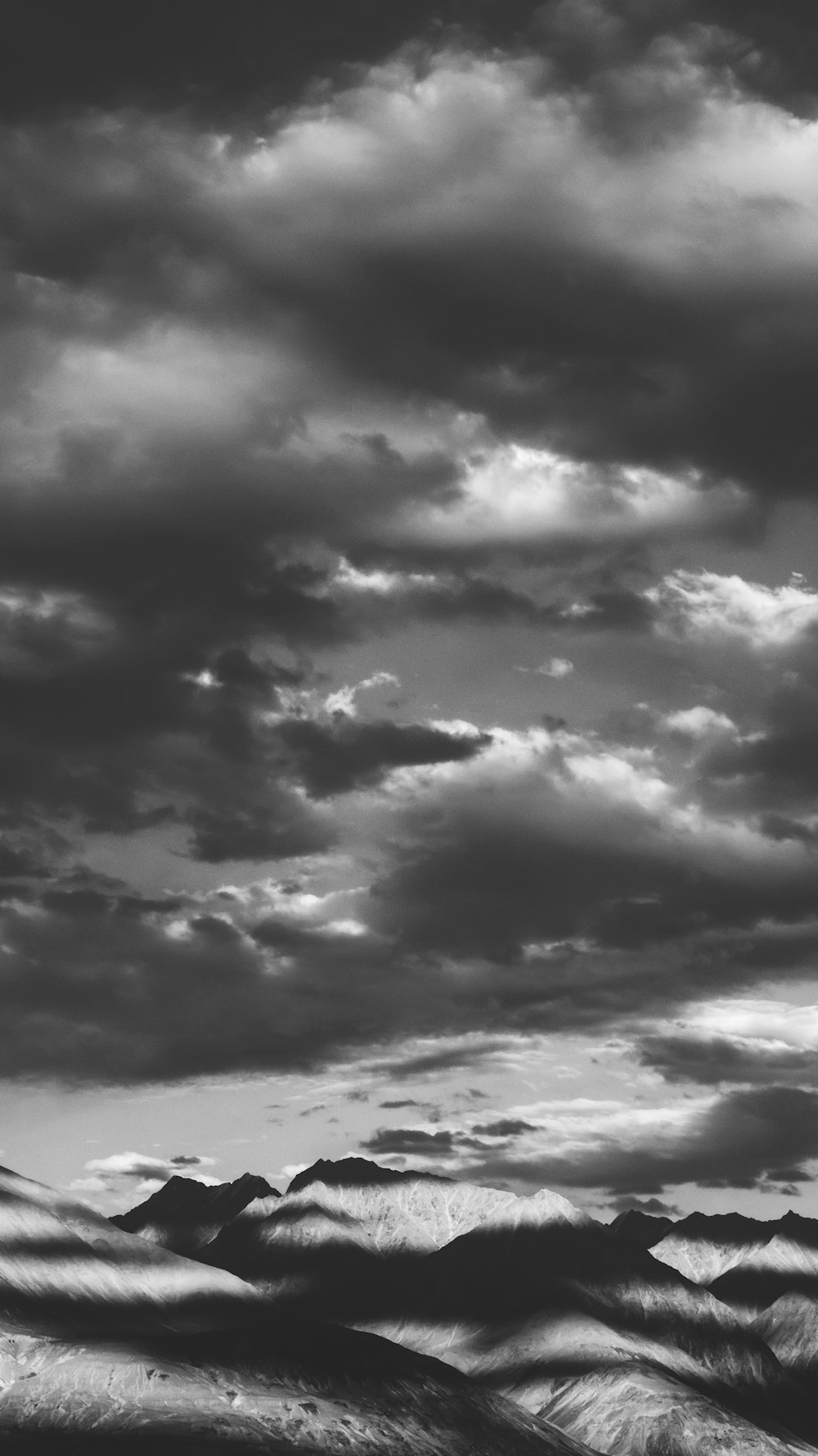 Fotografía en escala de grises de nubes sobre montañasm