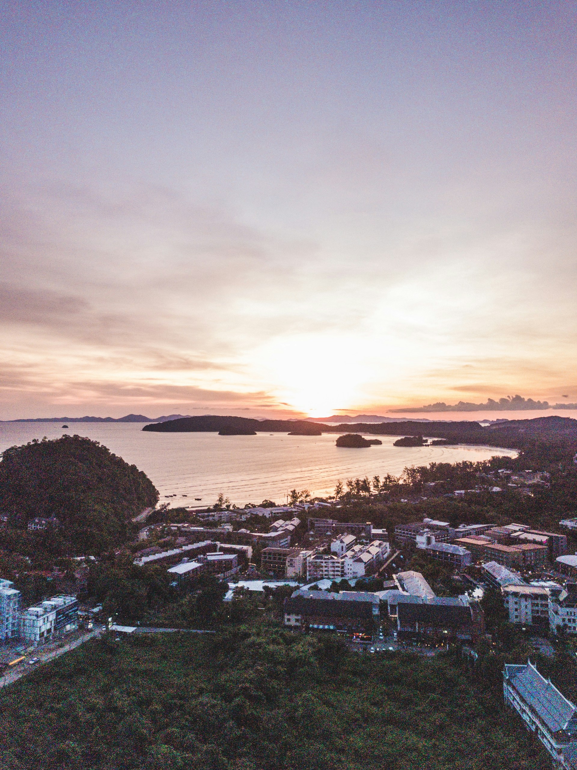 An aerial view of a picturesque coastal town, highlighting the blend of land and sea in a stunning sunset.