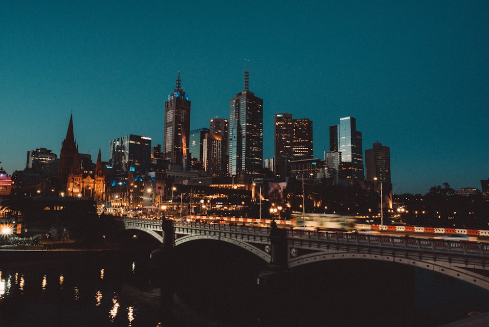 lighted bridge near city at night