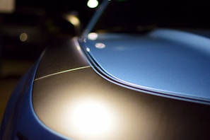 Close-up of a polished car hood reflecting sunlight.