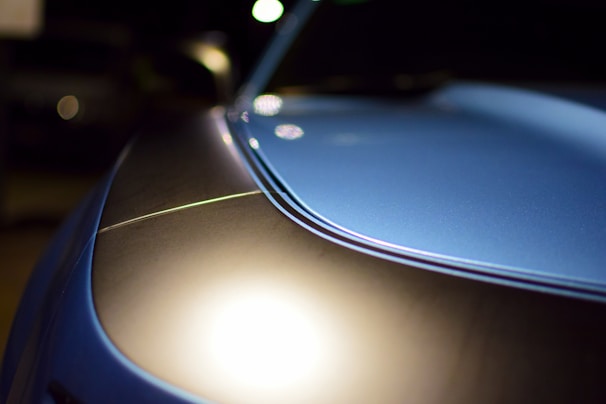 Close-up of a sleek car hood with a glossy self-healing paint protection film applied.
