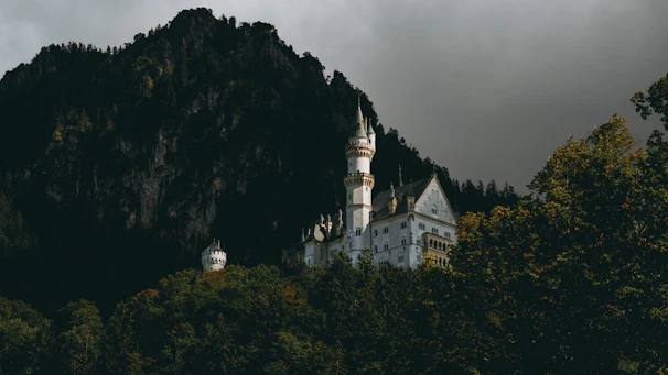 Fairytale-like Bouzov Castle with its pointed turrets against a cloudy sky.
