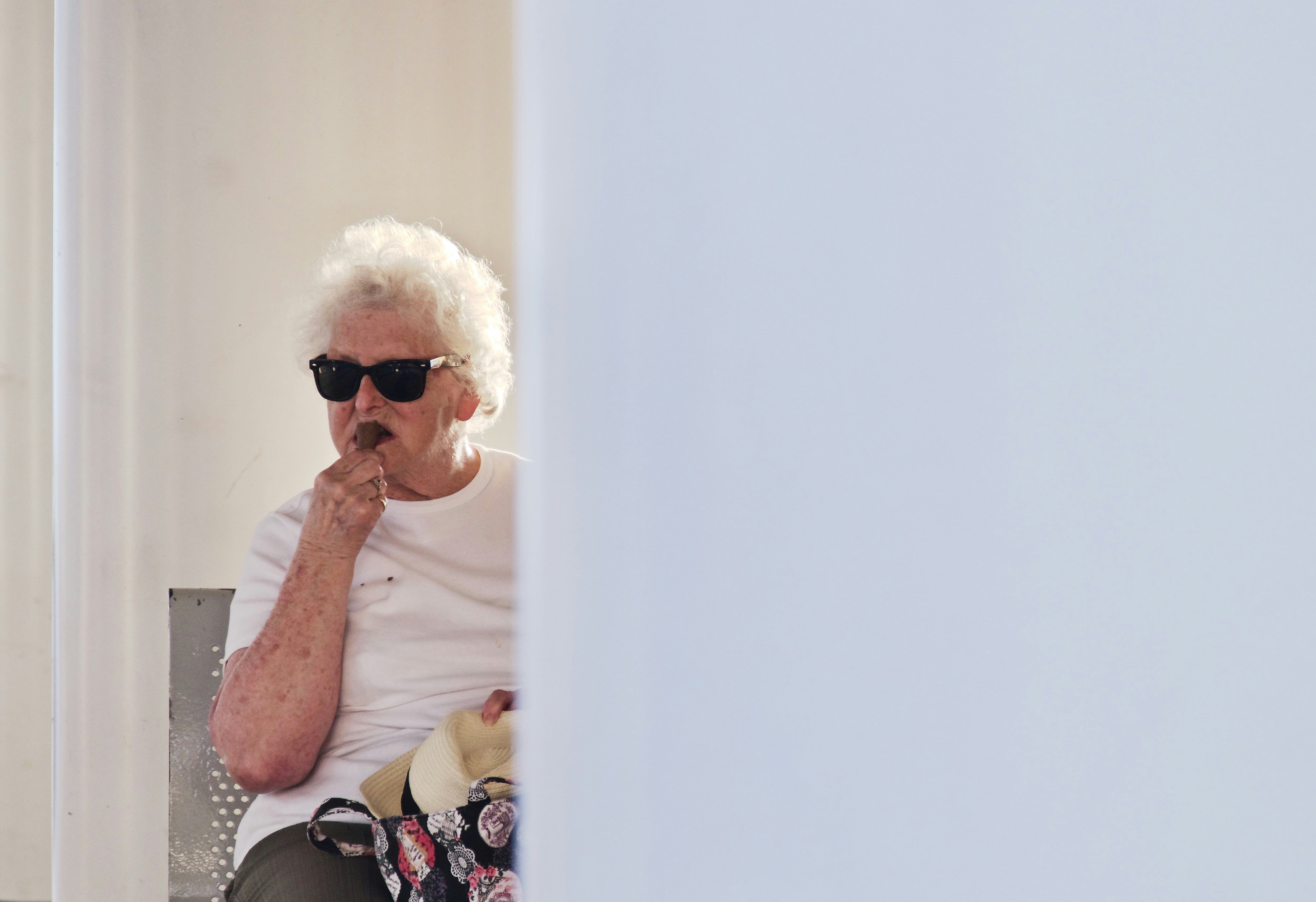 person wearing white crew-neck t-shirt and black framed sunglasses