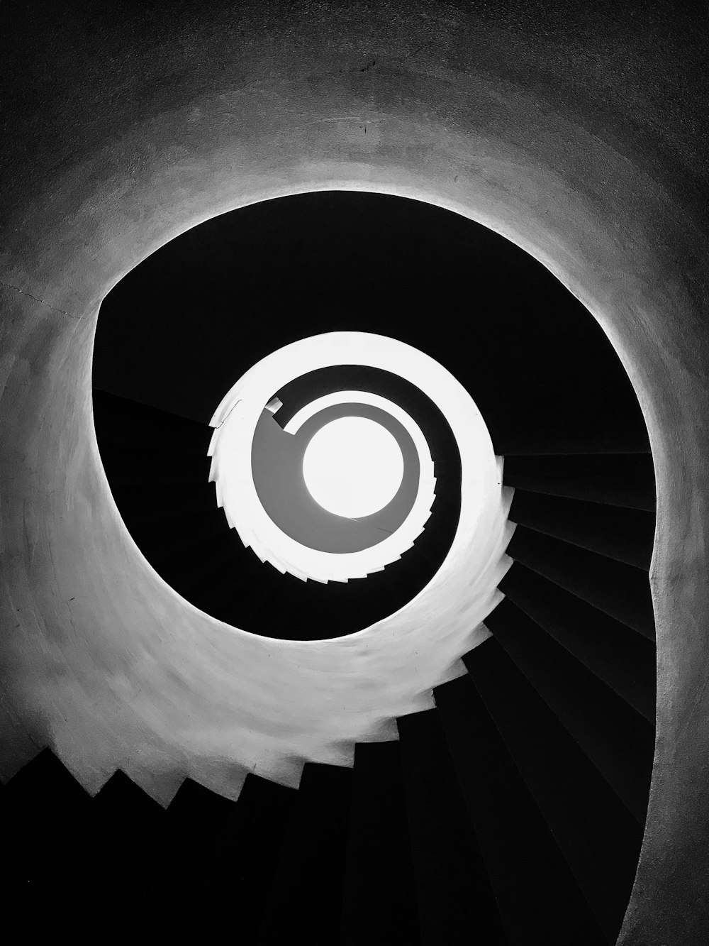 a black and white photo of a spiral staircase