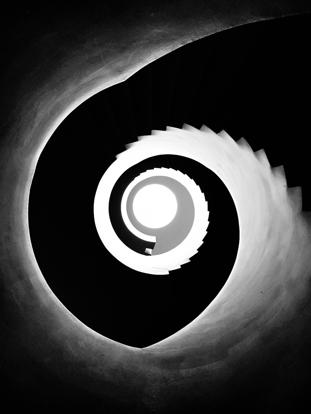 a black and white photo of a spiral staircase