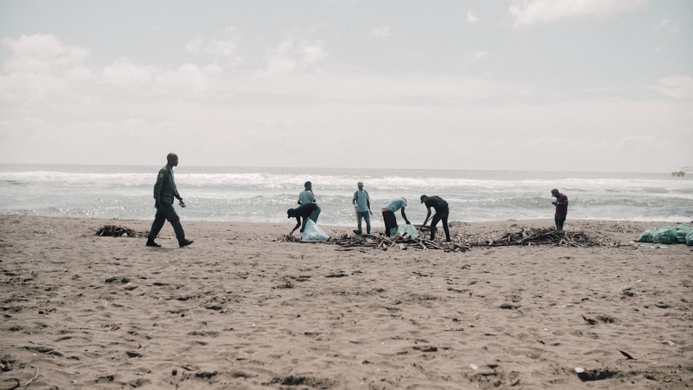 a group of people standing on top of a sandy beach