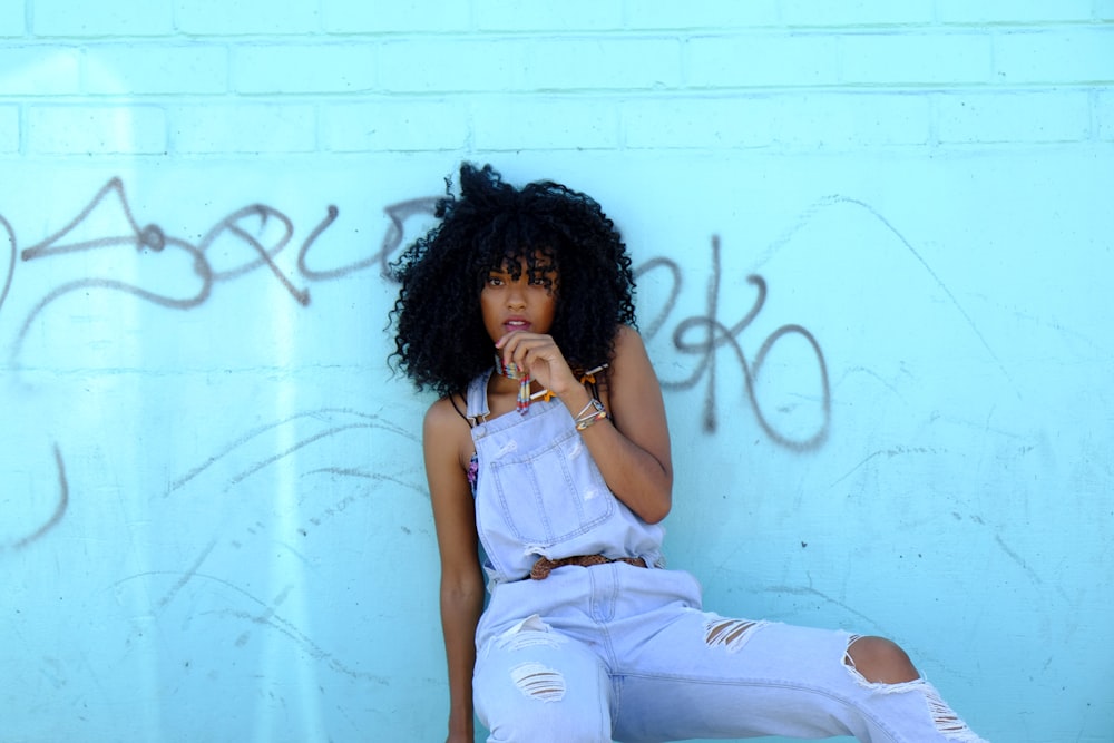 femme appuyée sur le mur bleu