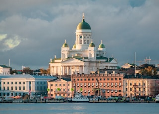 white concrete mosque near body of water