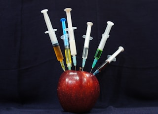 apple fruit with plastic syringes