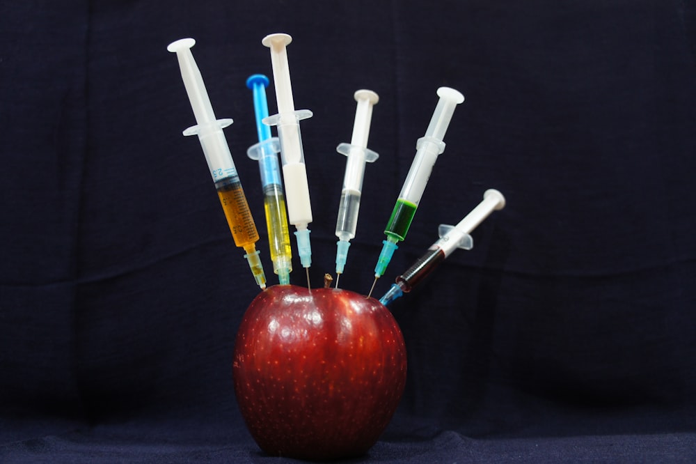 apple fruit with plastic syringes