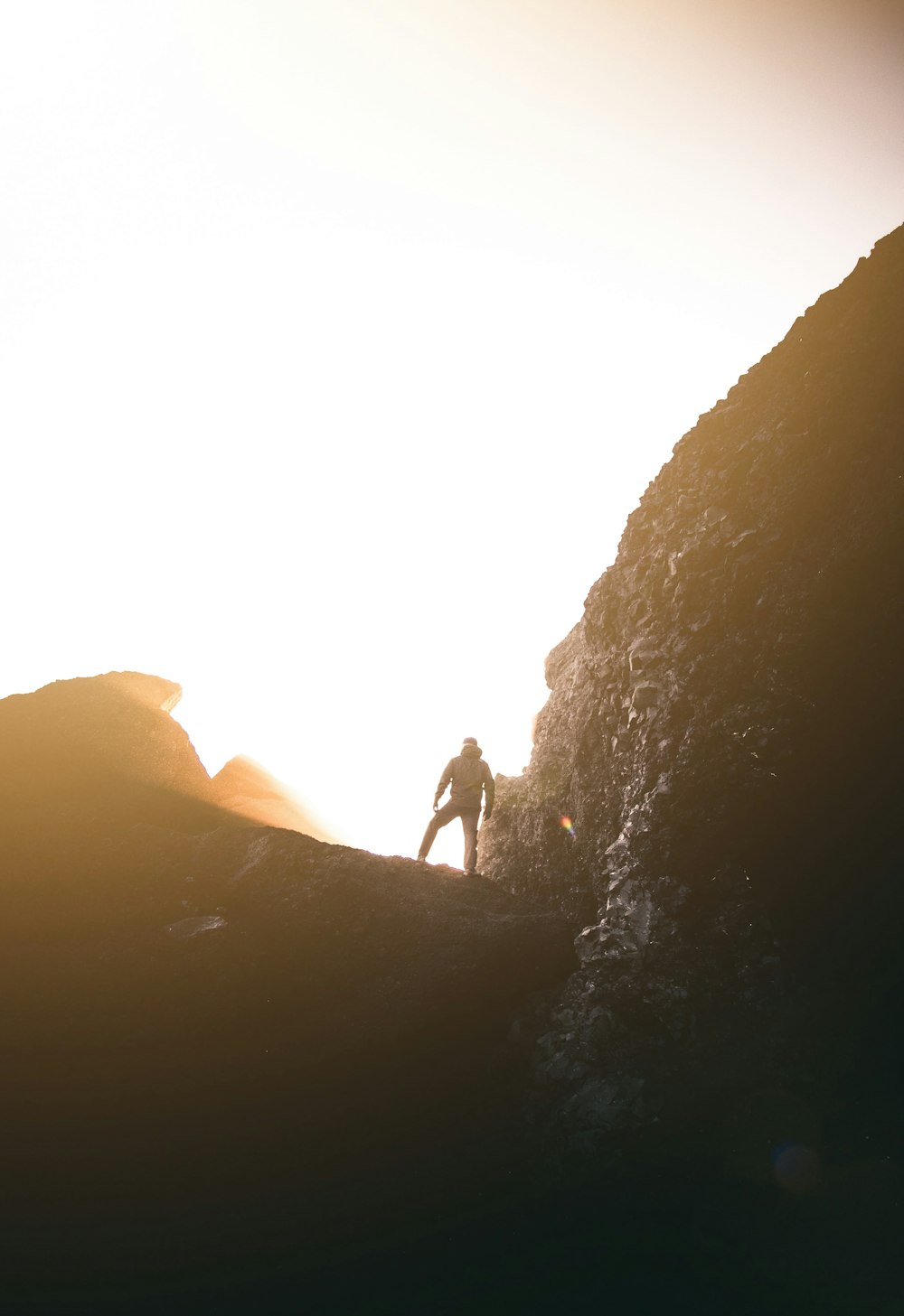 Silhouettenfotografie eines Mannes, der auf dem Berg steht