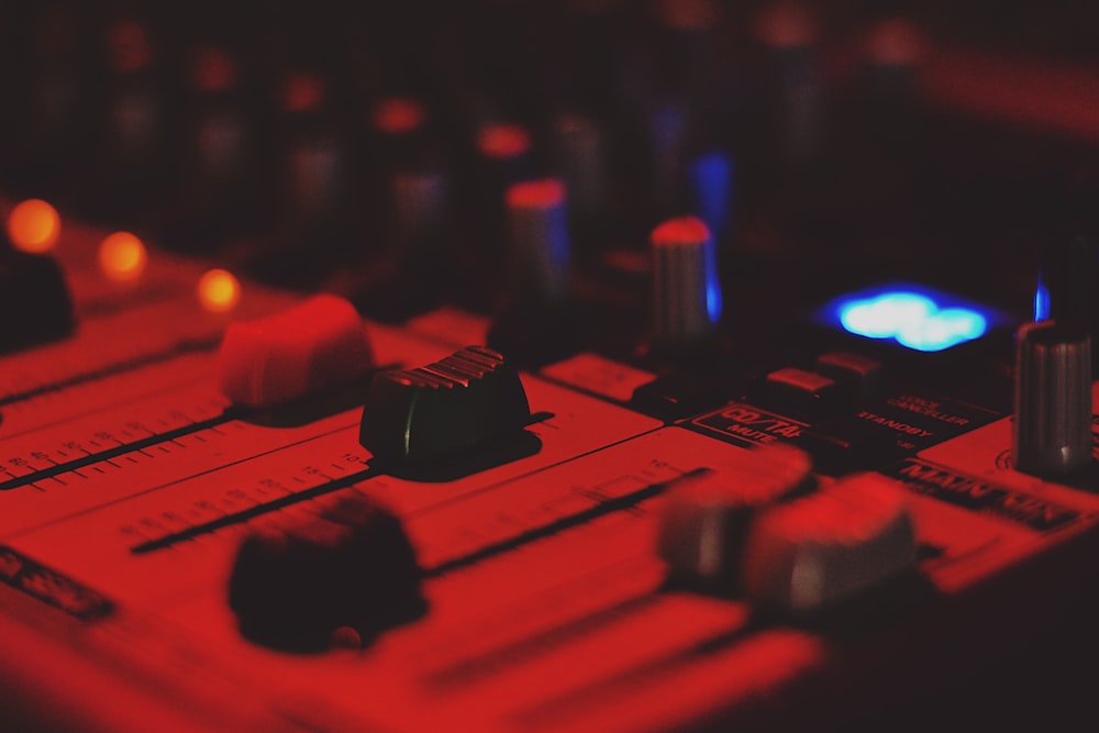 Foto de primer plano del mezclador de audio con luz tenue roja