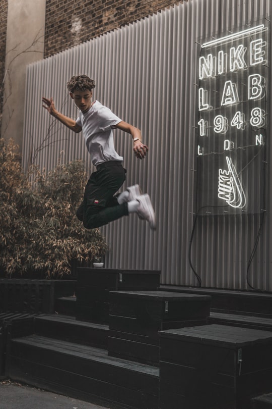 man jumping on black black platform in Shoreditch United Kingdom