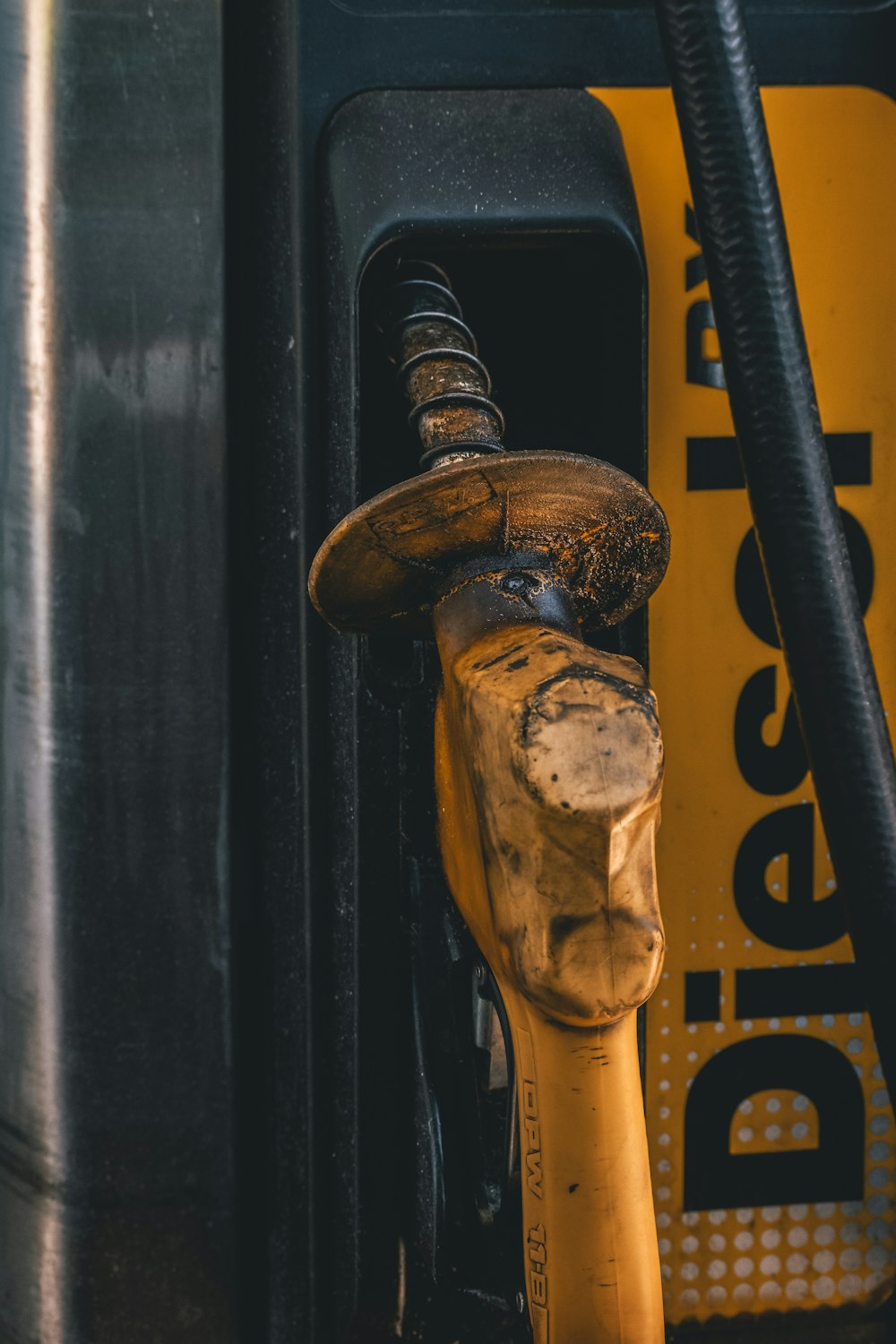 closeup photography of yellow and black gasoline pump during daytime