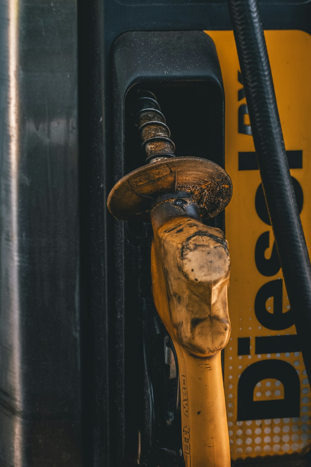 Photographie en gros plan de la pompe à essence jaune et noire pendant la journée