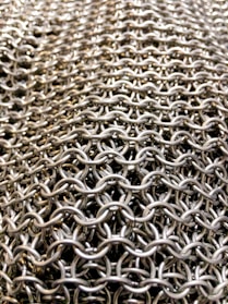 A large vertical photo showcasing intricate chain maille and scale maille outfits.