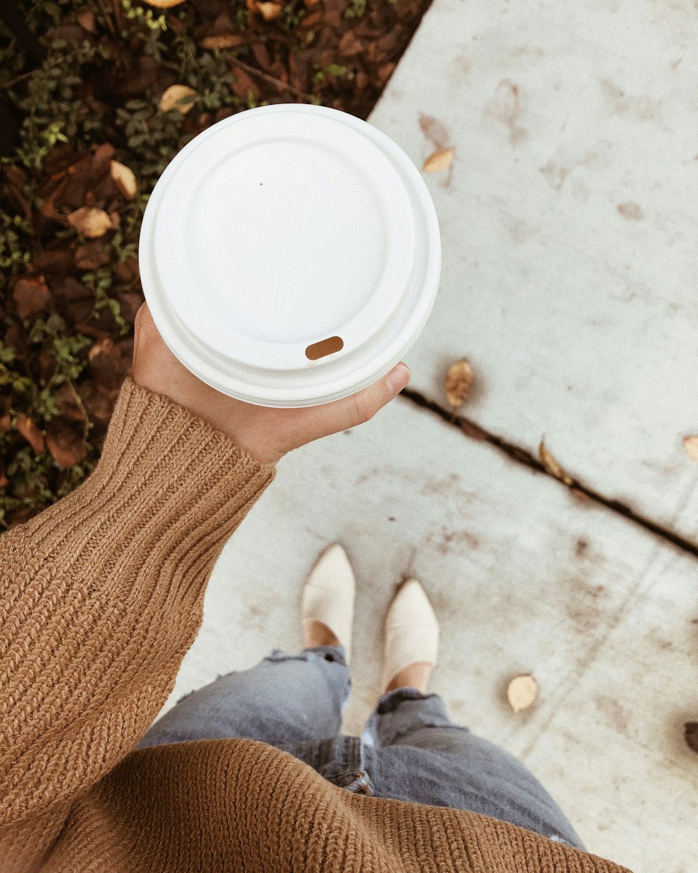 person holding white disposable cup