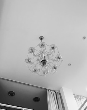 Electrician installing chandelier in a modern living room