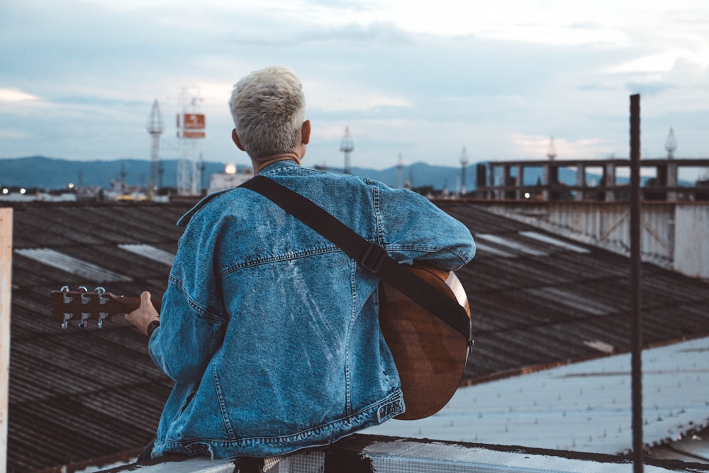 person playing guitar on rooftop