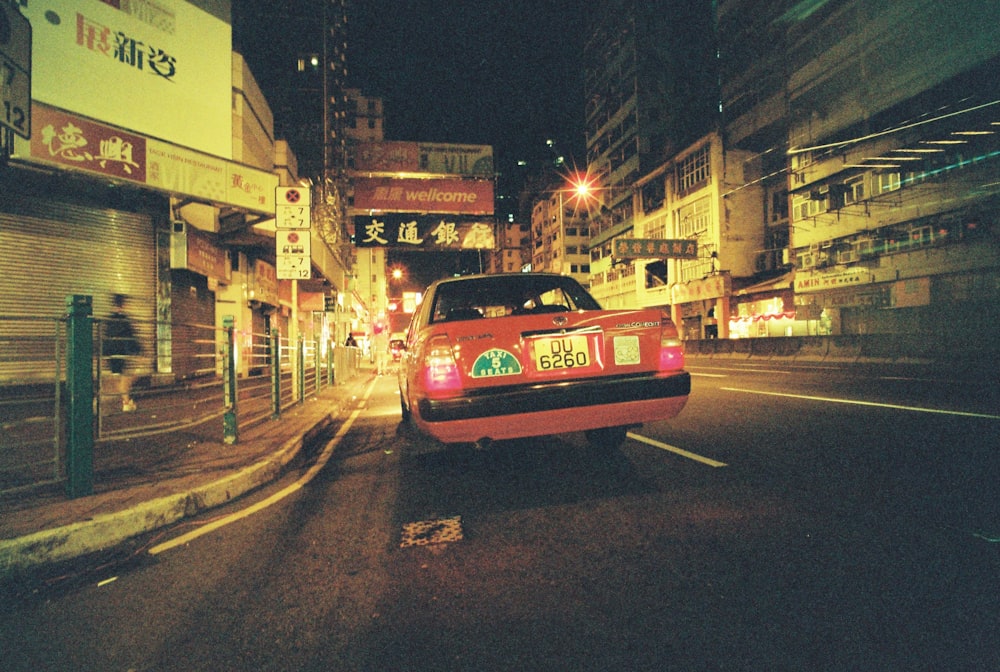 red vehicle on road during nighttime