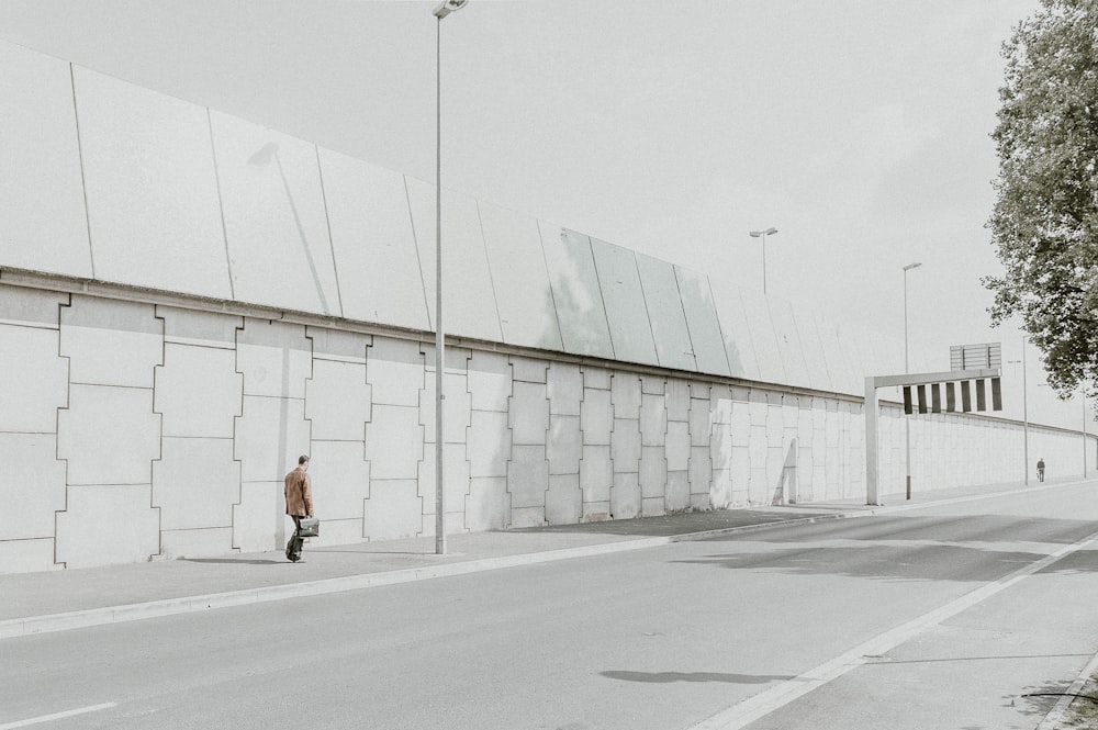 man standing near wall and post