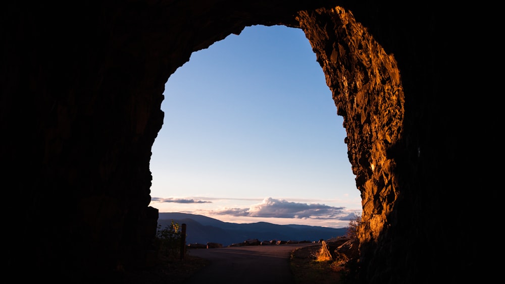 cave entrance with clouds and mountain in background