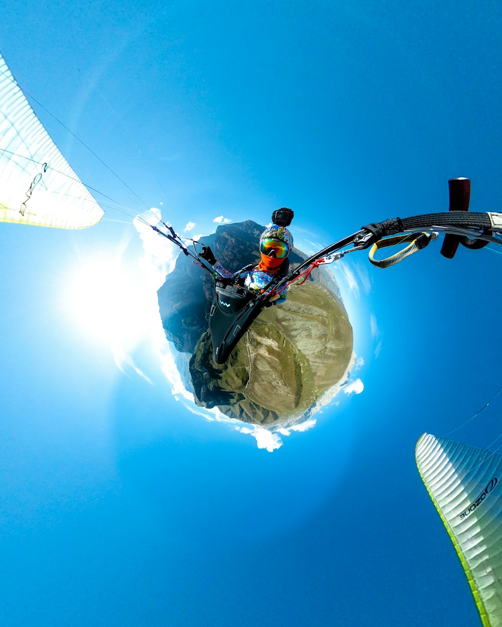 man standing on top of tower pole in little planet photography
