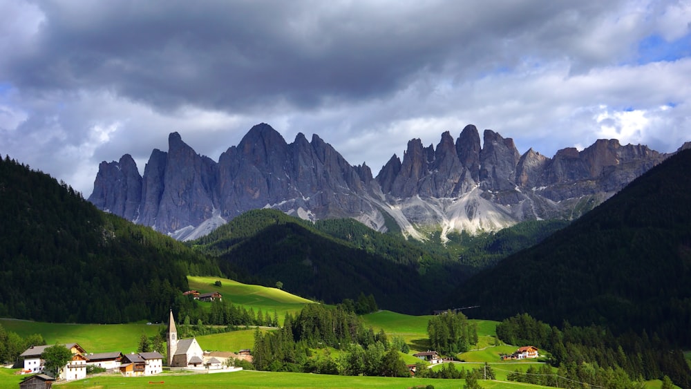 houses near mountain under cloudy sky