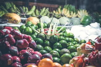 A vibrant display of fresh fruits including bananas, papaya, and pomegranates.