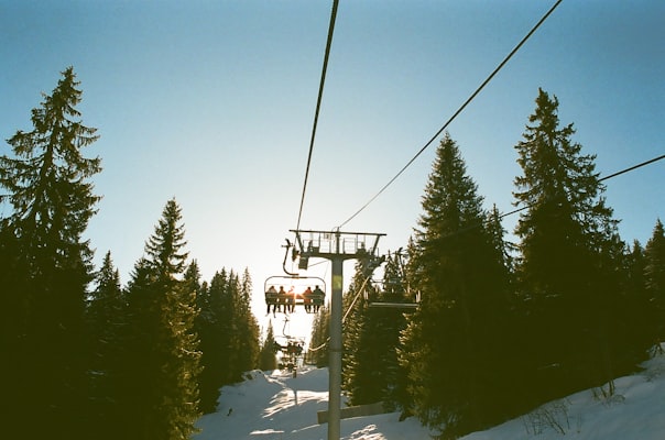 Skiers riding a chairlift through trees in Avoriaz