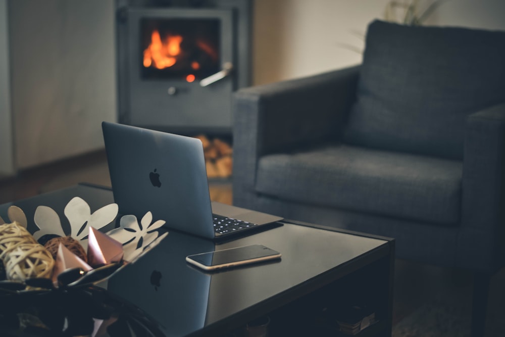 silver MacBook on black wooden table