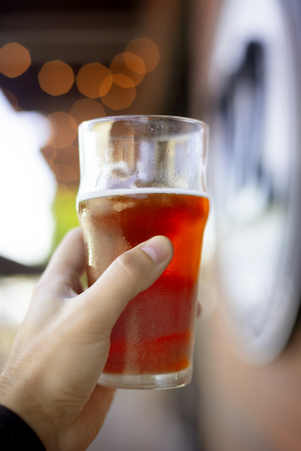 person holding pilsner glass