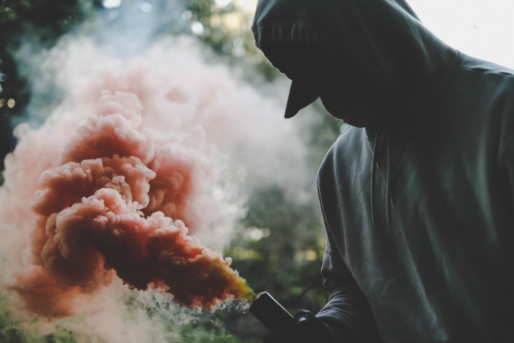 person holding orange smoke flare