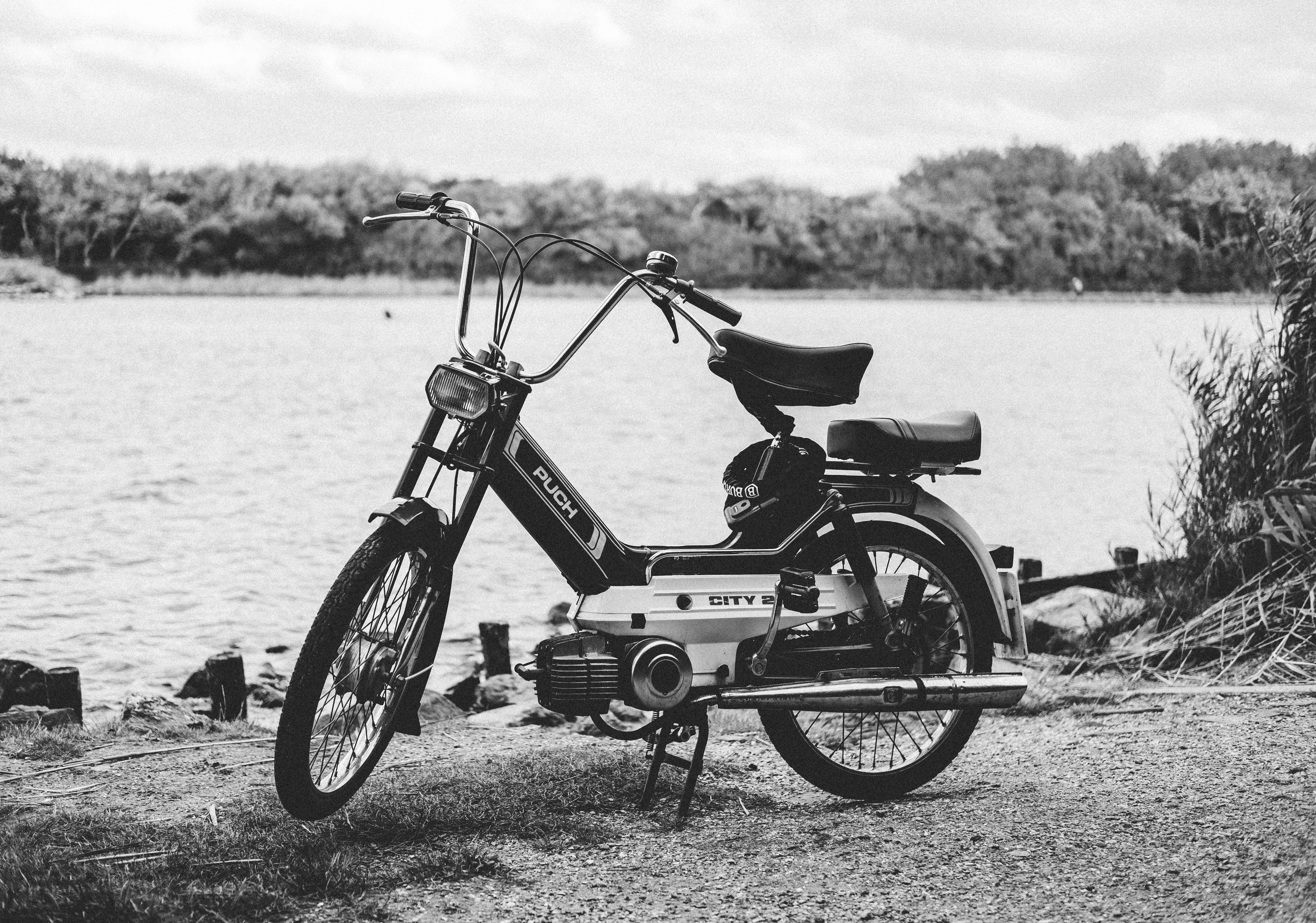 gray moped parked near body of water