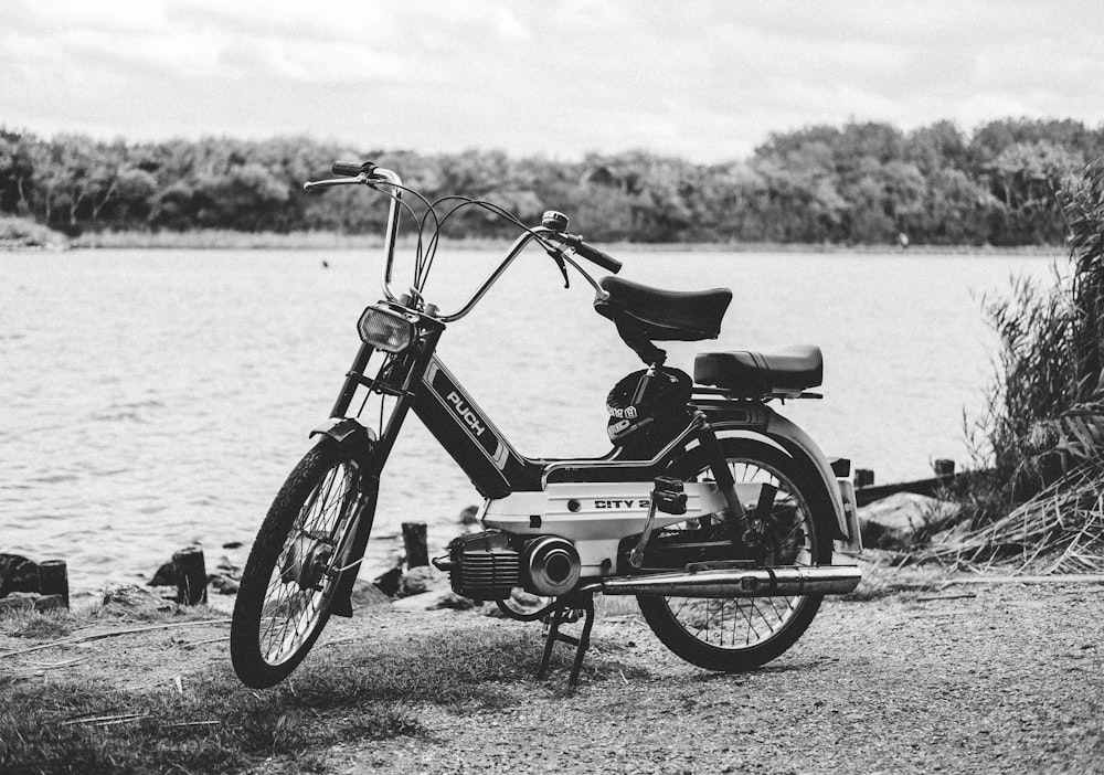 gray moped parked near body of water
