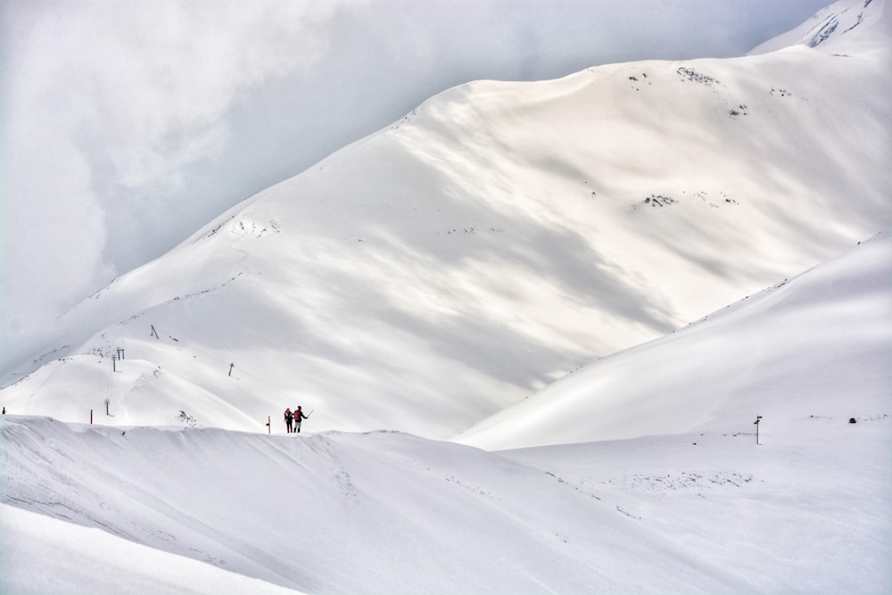 two people on hill mountain covered by snow