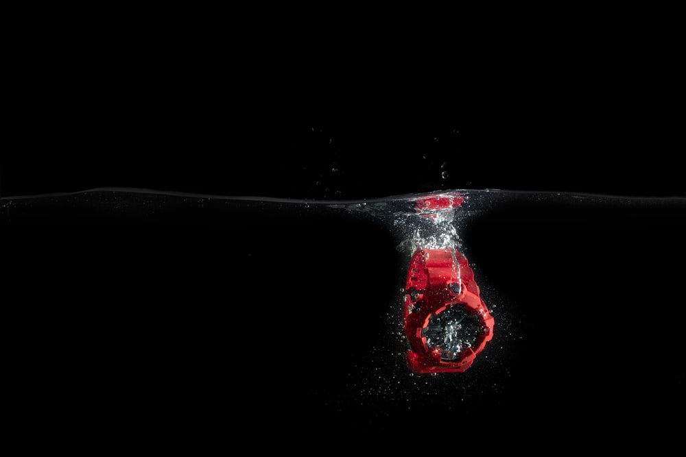 red digital watch in body of water
