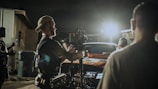 The crew setting up lights and cameras during a vibrant outdoor shoot at sunset.