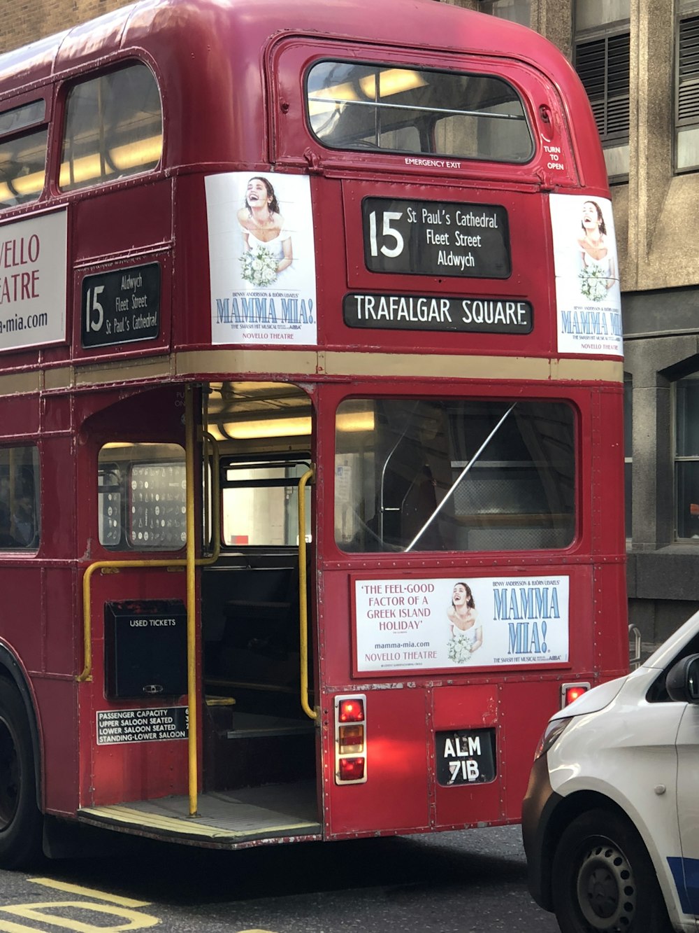 red double-decker bus traveling on road near buildings