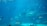 An underwater scene with a variety of marine life including a prominent whale shark at the center surrounded by different species of fish and rays. The water is clear, giving a deep blue hue to the environment, and small schools of colorful fish swim in harmony. The setting appears to be within a large aquarium.