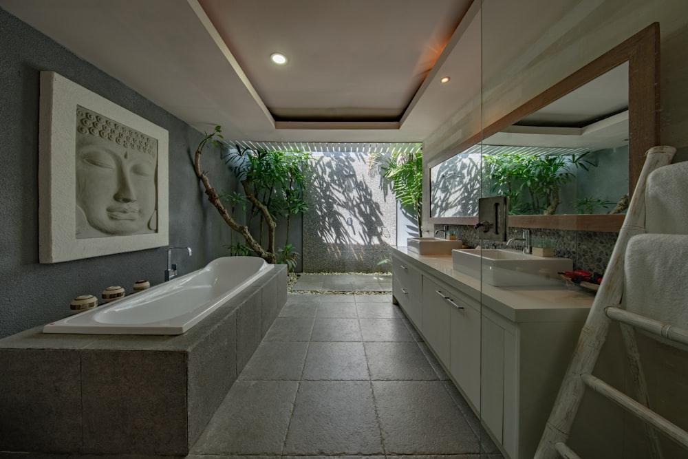 灰色の壁の横の白いセラミックの浴槽