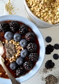 A rustic wooden bowl filled with ancient grain porridge topped with fresh berries and nuts.