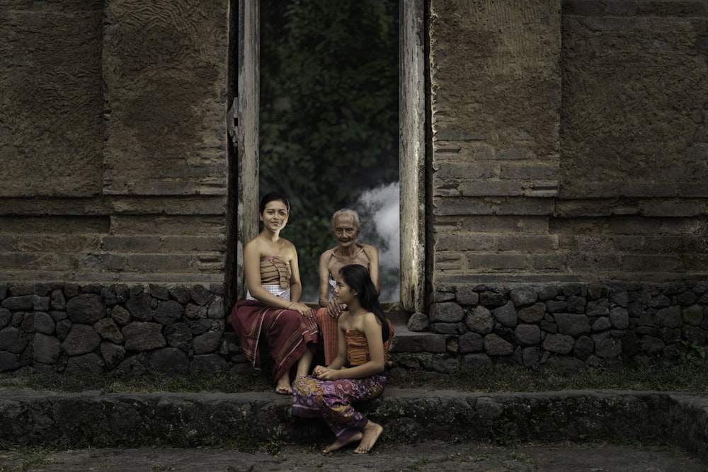 three girl sitting on chair