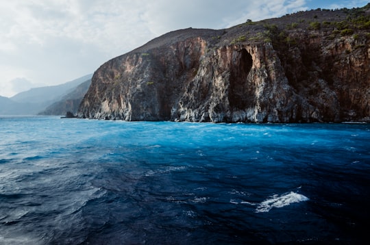 brown sea cliff under cloudy sky during daytime in Hora Sfakion Greece