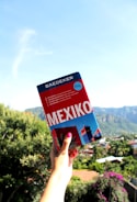A scenic travel destination with a suitcase and travel guidebook in the foreground.