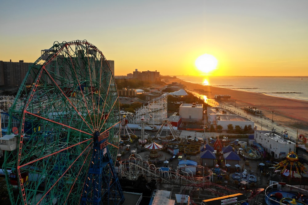 aerial photography of ferris wheel near body of water during golden hour